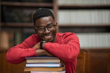 Afrikalı öğrenci kitap yığınında