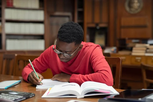 Студент в бібліотеці, що навчається на екзамен — стокове фото