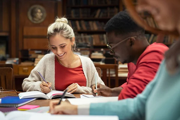 Gelukkige studenten studeren in de bibliotheek — Stockfoto