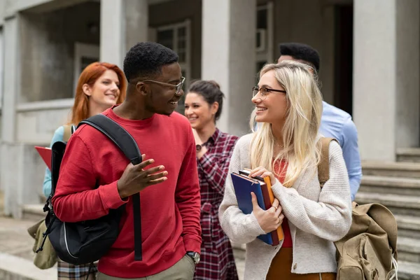 Amigos estudantes multiétnicos andando no campus universitário — Fotografia de Stock