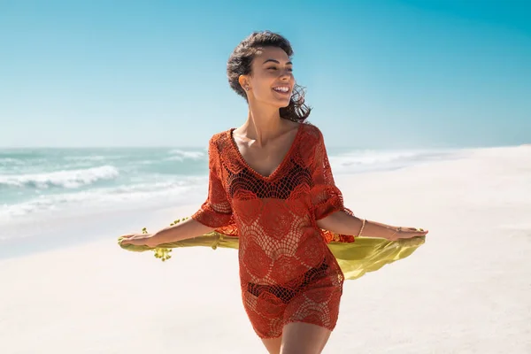 美丽的微笑的女人带着绿色的围巾在海滩上奔跑 背景是海滨 快乐时尚和活泼的女孩飞行组织和享受暑假 迷人的女孩穿着红色时尚钩针裙在海上散步 — 图库照片