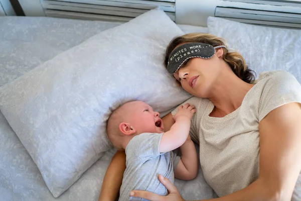 Trött Mamma Med Ögonband Försöker Sova Medan Lilla Barn Gråter — Stockfoto