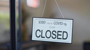 Covid-19 salgını yüzünden dükkan kapanmış. Halka açık yerlerde ve restoranlarda karantina önlemleri nedeniyle küçük bir iş etkinliğinde koronavirüs için geçici olarak kapalı işaret. Mağaza veya kafenin camından kapalı tabela levhasıyız.. 