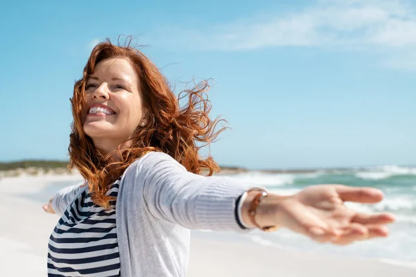 Gelukkig Volwassen Vrouw Met Uitgestrekte Armen Voelt Wind Het Strand — Stockfoto