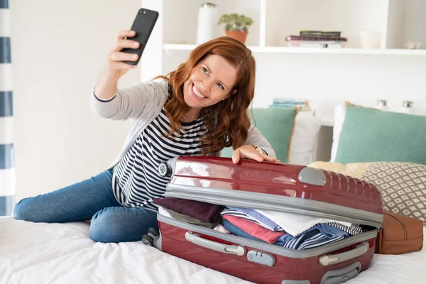 Beautiful Mature Woman Taking Selfie Overstuffed Suitcase Leaving Trip Cheerful — Stock Photo, Image