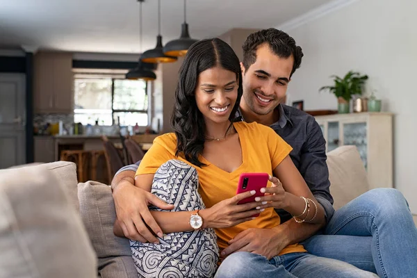 Gemischtes Junges Paar Mit Mobiltelefon Sitzt Zusammen Auf Dem Sofa — Stockfoto