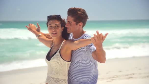 浪漫的拉丁夫妻 张开双臂 在海滩享受夏天 在海上度蜜月时 可爱的丈夫与美丽的妻子聊天 在阳光灿烂的日子里 在海滩上张开双臂 快乐地微笑着的年轻夫妇 复制空间 — 图库视频影像