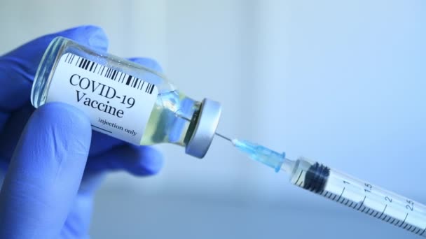 의사는 Covid 백신을 추출하고 백신을 주사기 주사를 채운다 장갑을 주사기가 — 비디오