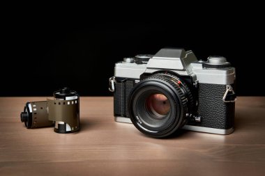  Klasik analog 35 mm kamera ve film ahşap masa üzerinde antika sarar.