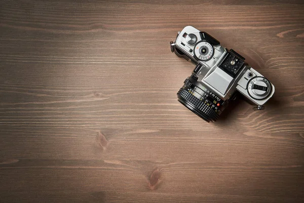Tahta masa üzerinde klasik bir analog 35 mm kamera klasiğinin üst görüntüsü