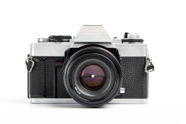 Beyaz zemin üzerinde klasik bir analog 35 mm kamera vintage ve analog film rulolarının ön görüntüsü