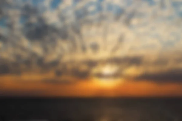 Fundo borrão - Pôr do sol sobre o oceano com nuvens dramáticas — Fotografia de Stock