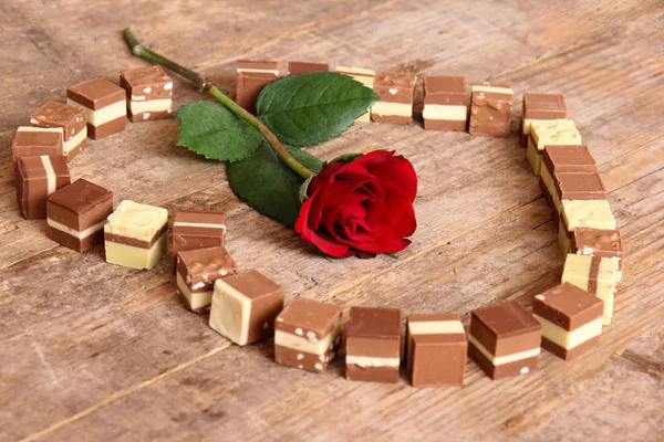 Rudá růže v kruhu tvar srdce mini pralinky čokolády — Stock fotografie