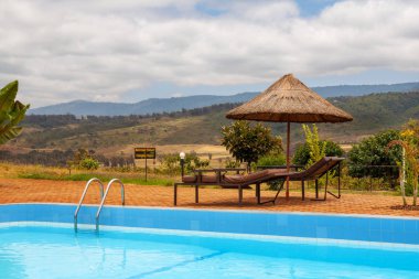 Bir vahşi Afrika arazi saman kulübe ile Açık Yüzme Havuzu