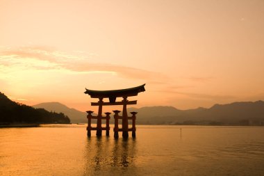 Günbatımı Itsukuşima, Japonya Nehri üzerinde kırmızı Torii kapaklı
