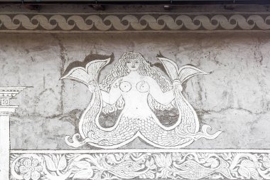İsviçre 'nin Berguen / Bravuogn şehrinde Sgraffito tekniğinden bir denizkızı figürüyle geleneksel ev cephesi. Sgraffito tekniği zıt renklerde renklerle renklendirilmiş alçı tabakalarını nemli bir yüzeye uygular.
