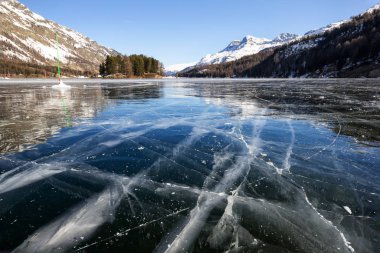 Frozen lake with ice cracks on surface on a sunny, cold winter day (focus stacking)