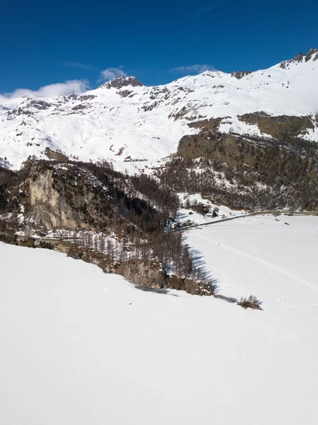 凍った湖の表面とクロスカントリースキーや散歩のためのトラックを覆う雪の凍った湖の上の島の先端の空中ビュー — ストック写真