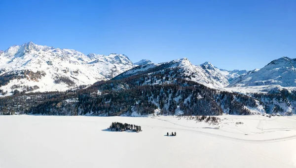 雪に覆われたシルセーの湖の表面でスポーツをしている人々とChaviolas島とイゾラの空中像 セントモリッツ スイス — ストック写真