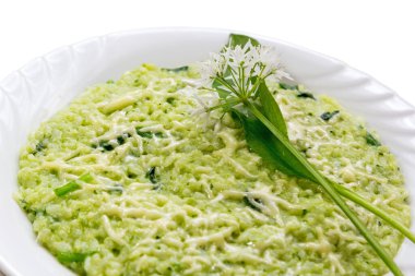 Ramsonlar (yaban sarımsaklı pırasa) parmesan peynirli risotto, beyaz arka planda taze Ramson yaprakları ve çiçeklerle servis edilir.