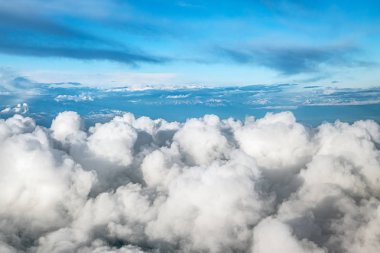 Alaska 'nın karlı dağları üzerinde kabarık bulutlarla dolu bir hava manzarası..
