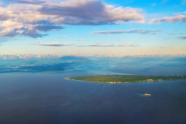 An aerial view of an Alaskan landscape with cruise ship.