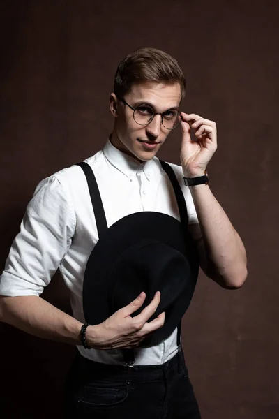 丸い眼鏡、サスペンダー、白いシャツと帽子の男. — ストック写真