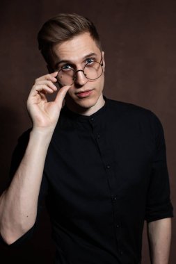 Man in round glasses and a black shirt.