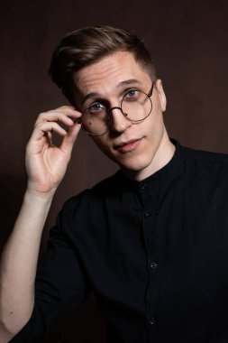 Man in round glasses and a black shirt.