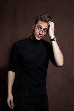 Man in round glasses and a black shirt.
