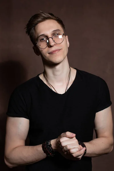 Handsome man in round glasses, a black t-shirt with bracelets — Stock Photo, Image