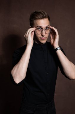 Man in round glasses and a black shirt.