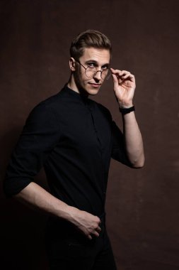 Man in round glasses and a black shirt.