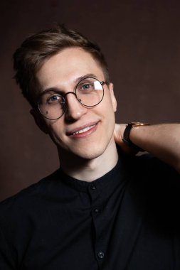 Man in round glasses and a black shirt.