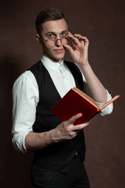 Yuvarlak gözlüklü adam kitap okuyor.