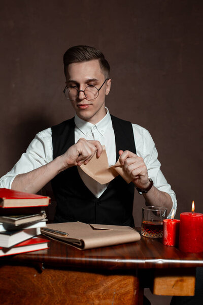 man in round glasses with writes a book