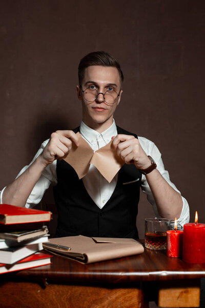 man in round glasses with writes a book