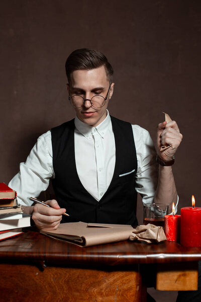 man in round glasses with writes a book