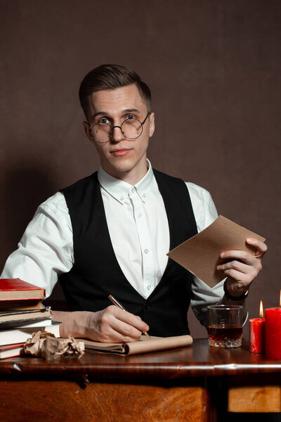man in round glasses with writes a book