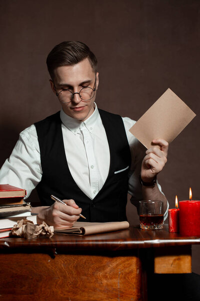 man in round glasses with writes a book