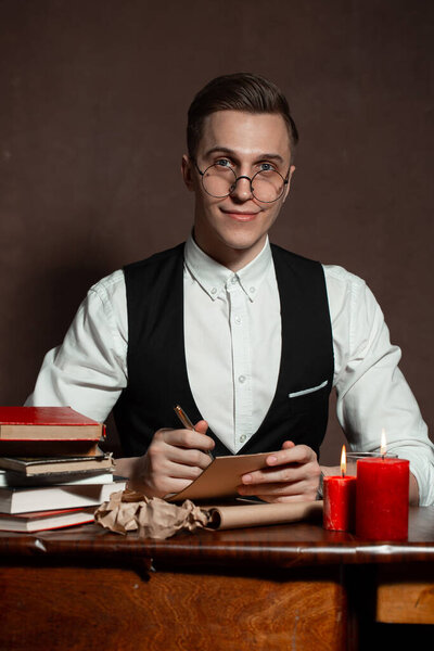 man in round glasses with writes a book