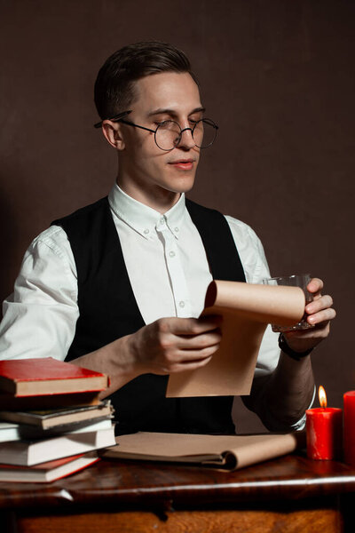 man in round glasses with writes a book