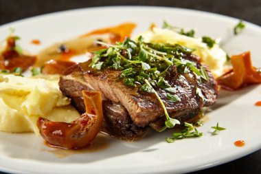 Et eti ve patates püresi beyaz tabakta.