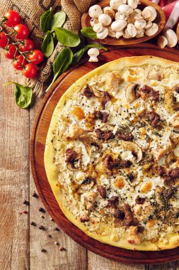 Tahta masa manzaralı mantarlı pizza.