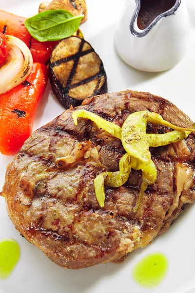 Makroaufnahme von Schweinenackensteak mit gegrilltem Gemüse isoliert — Stockfoto