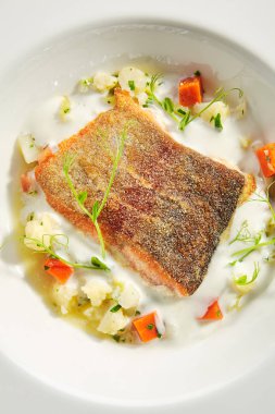 Kremalı alabalık filetosu ve sebze güveci izole edildi.