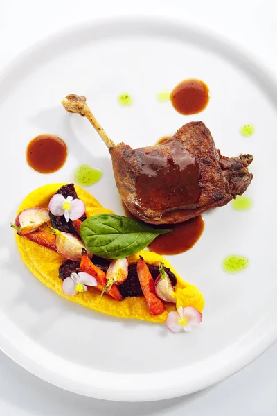 Perna de pato frito com legumes jovens, flores e creme de cenoura — Fotografia de Stock