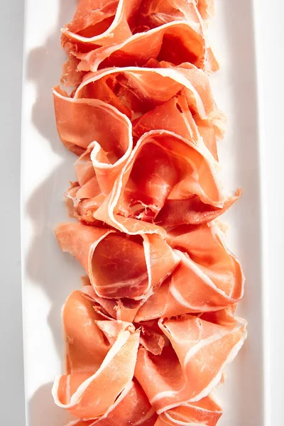 Sliced Jamon Iberico, Prosciutto or Speck on Restaurant Plate Is — стокове фото