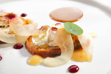 Krem peynirli ve armut dilimli yuvarlak Brioche tostu.