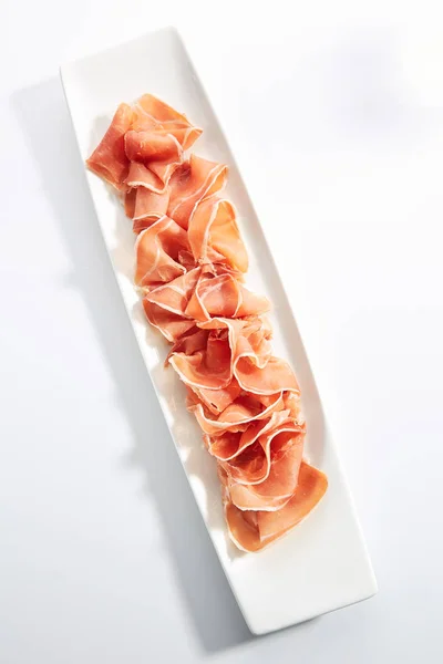 Sliced Jamon Iberico, Prosciutto or Speck on Restaurant Plate Is — стокове фото